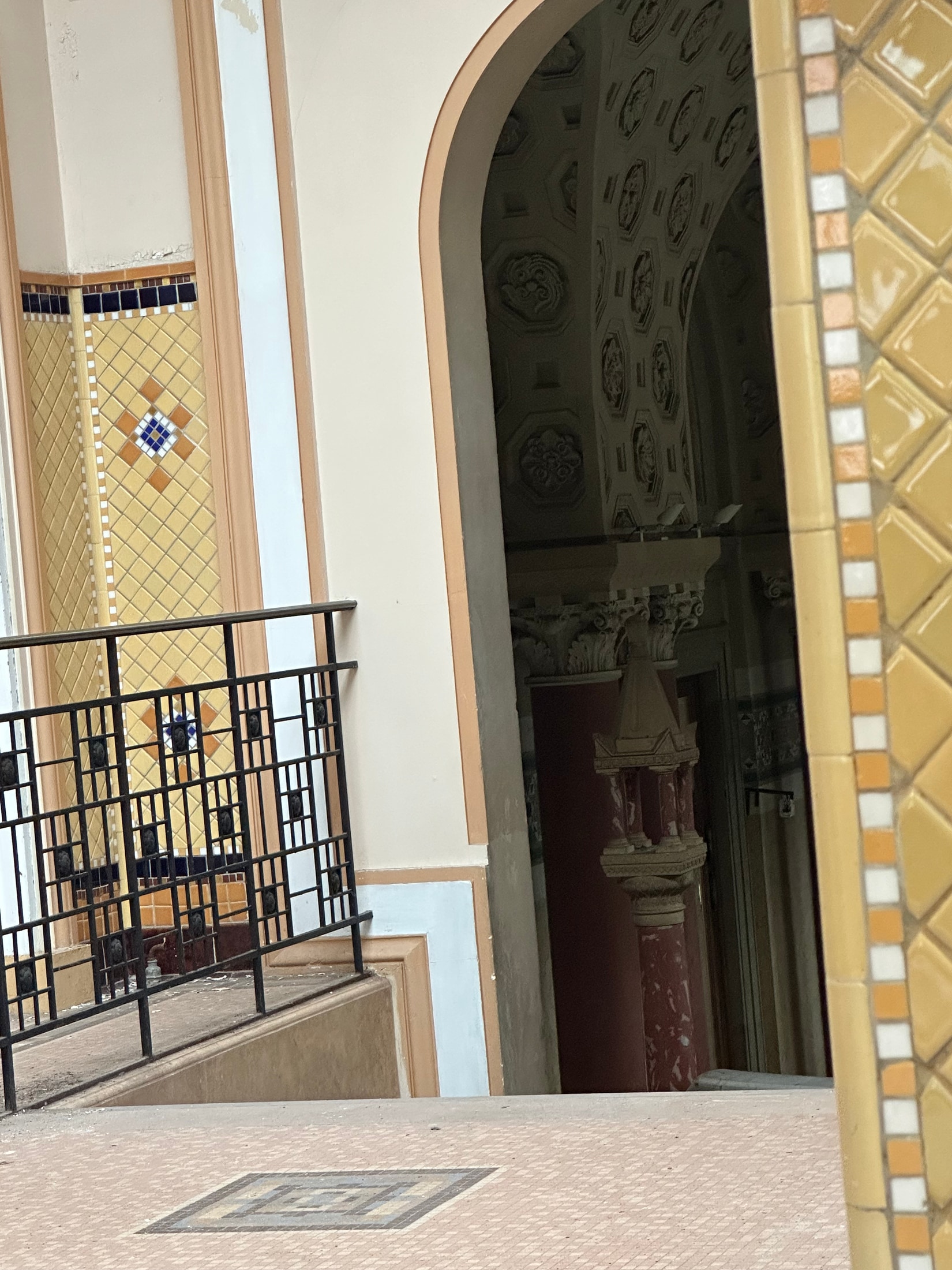 Detailblick in die Therme: Fliesenornamente, Geländer und historische Deckenstruktur