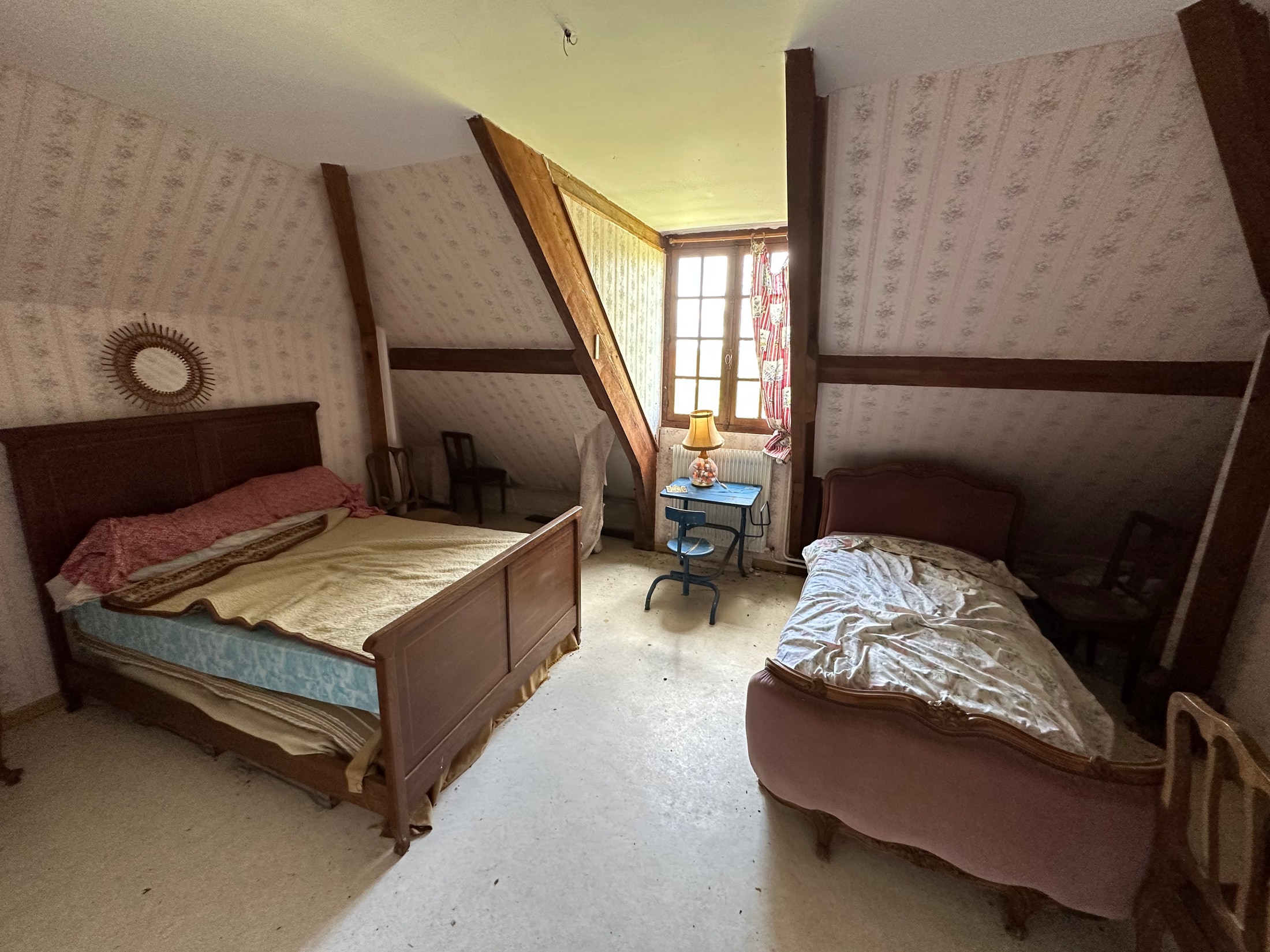 Zimmer mit zwei Betten, Tageslicht am Fenster und verblassten Textilien